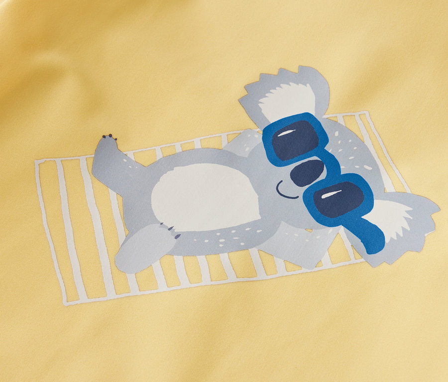 Žluté dětské tričko s UV faktorem 80 s potiskem ležící koaly v modrých slunečních brýlích.