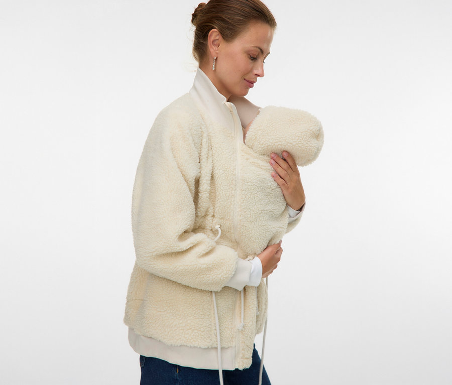 Žena drží dítě v bundě MAMALICIOUS MLCARLY 3IN1 TEDDY JACKET. Bunda je světle béžová a z plyšového materiálu.