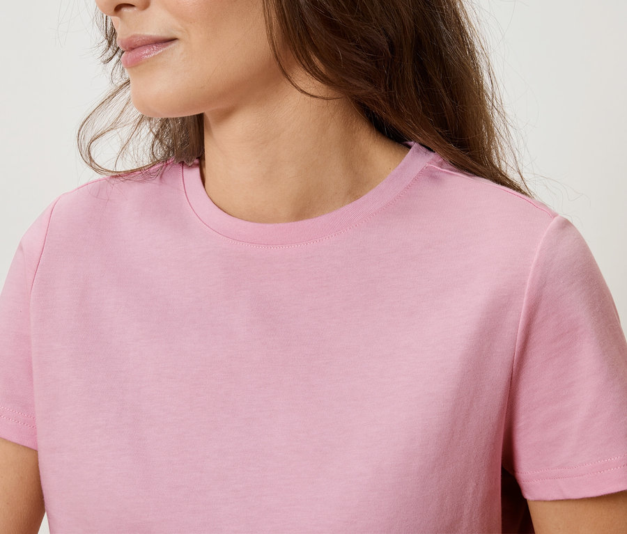 Detailní záběr ženy v růžovém tričku.