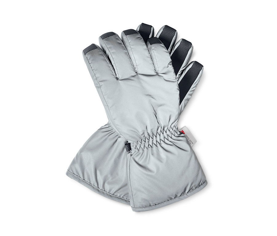 Dvě reflexní zimní rukavice leží na sobě.