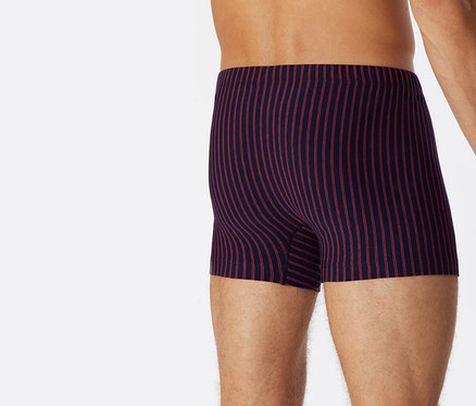 Muž zezadu má na sobě červené trenýrky SCHIESSER s biobavlnou.