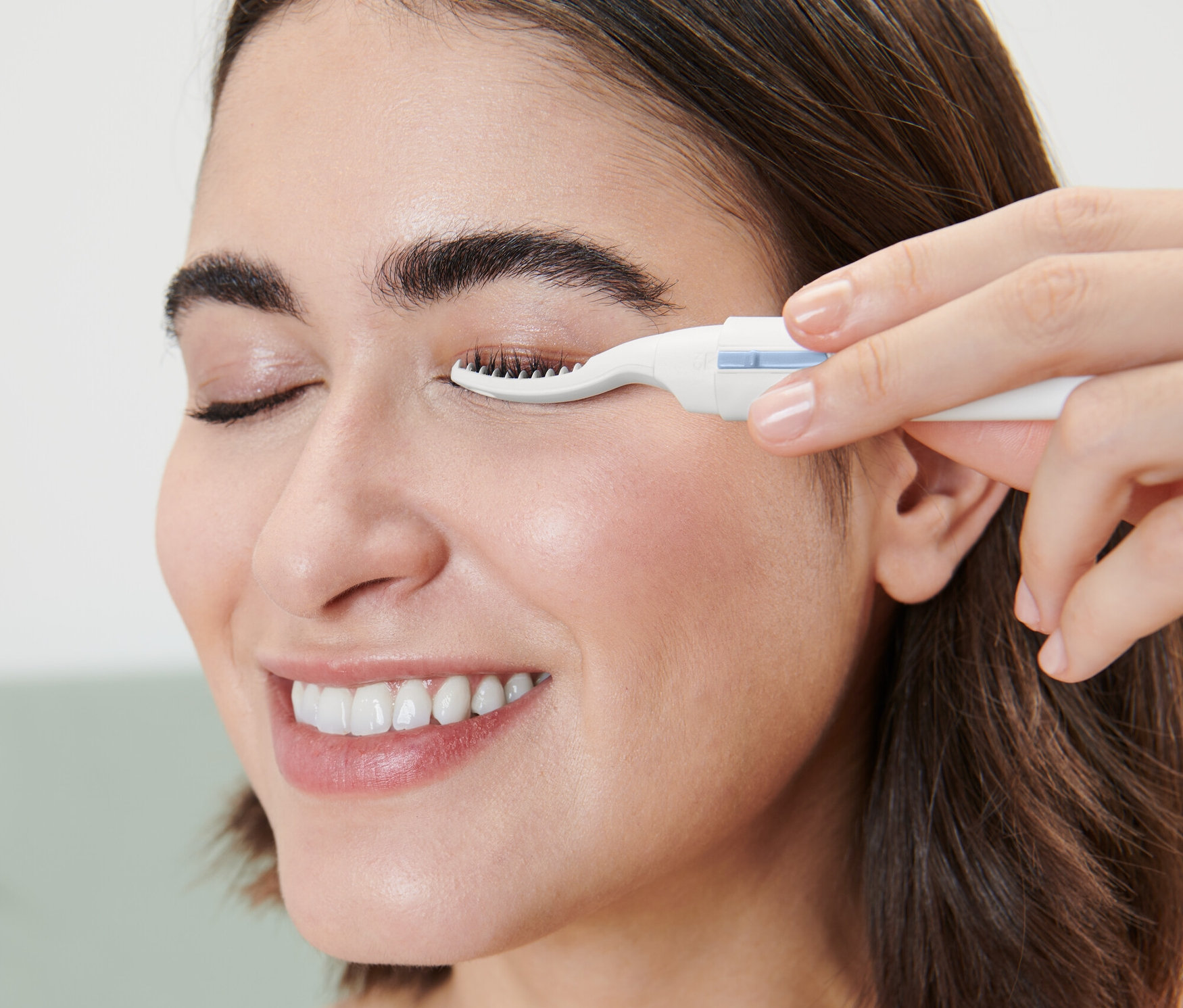 Žena používá vyhřívanou kulmu na řasy.