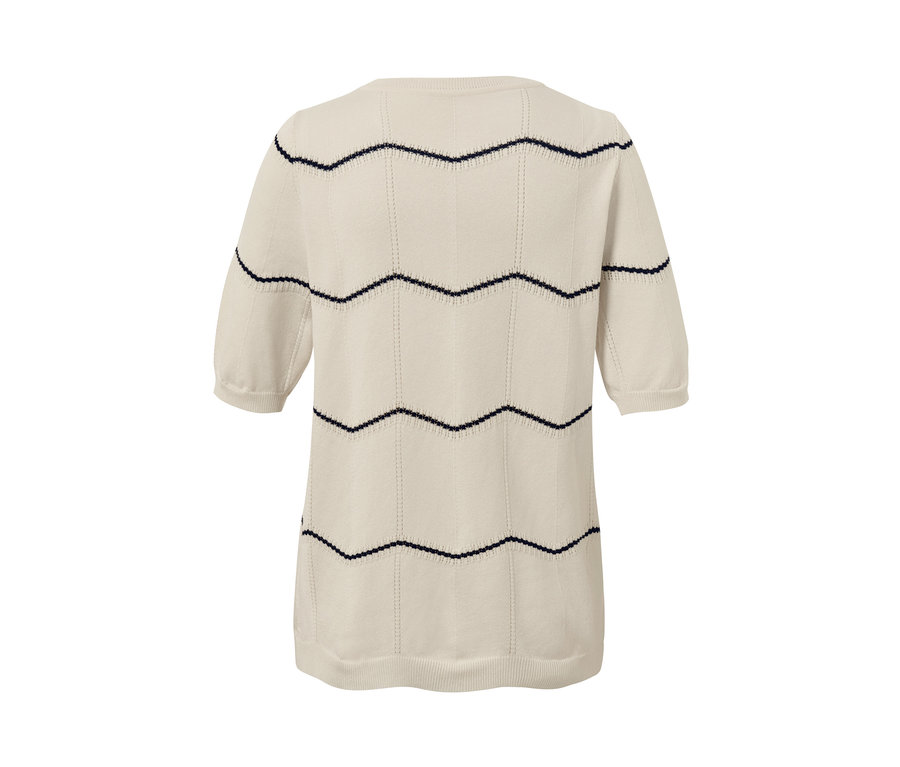 Béžový kardigan z jemné pleteniny s tmavě modrým ažurovým vzorem.