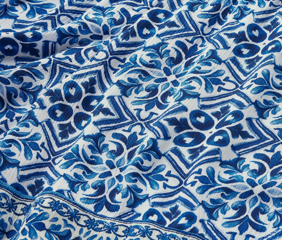 Detail tkaných šortek s modrobílým potiskem.