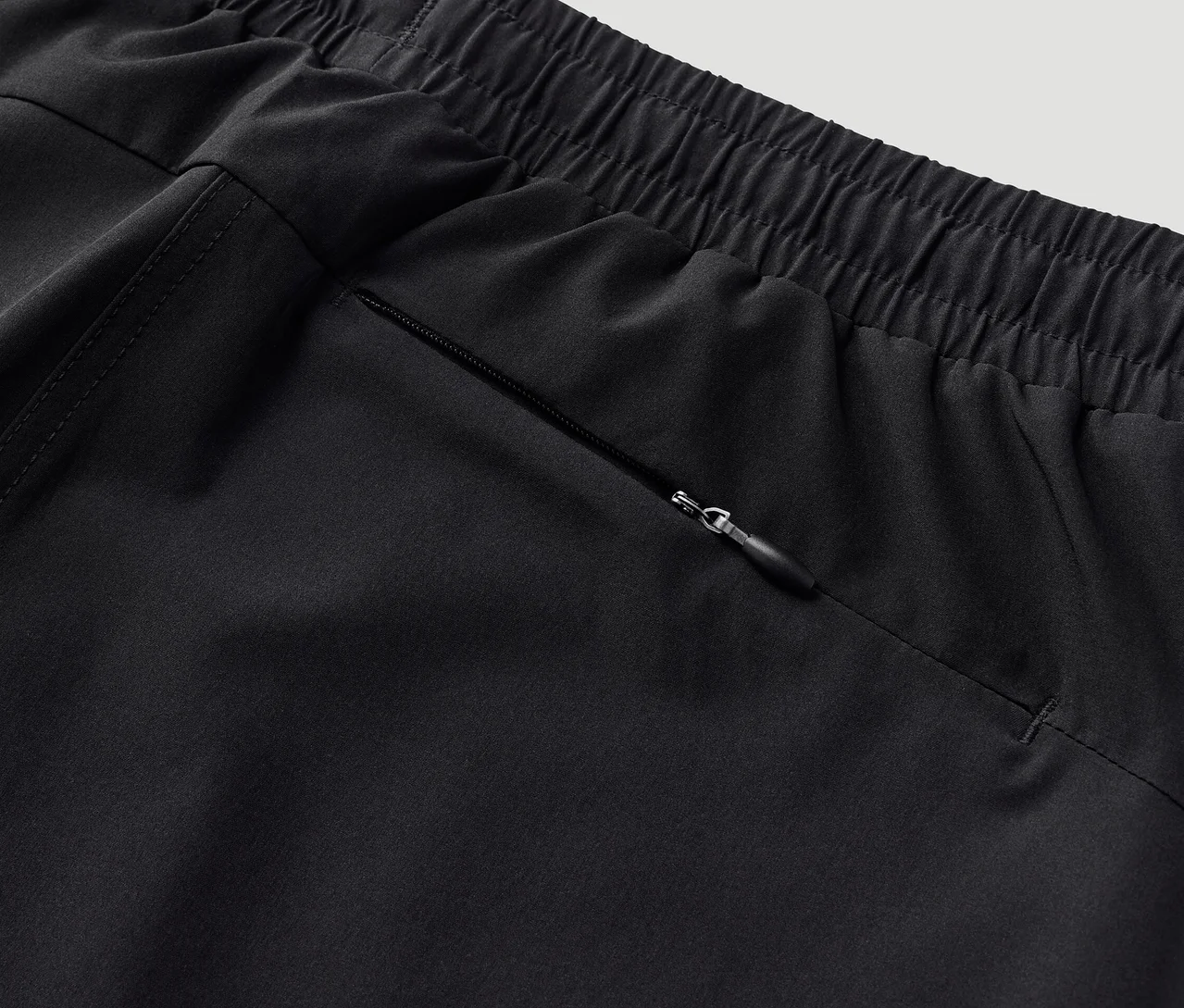 Detail funkční kraťasové sukně s kapsou na zip.