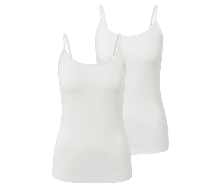 Dvě bílá tílka se špagetovými ramínky leží na sobě.