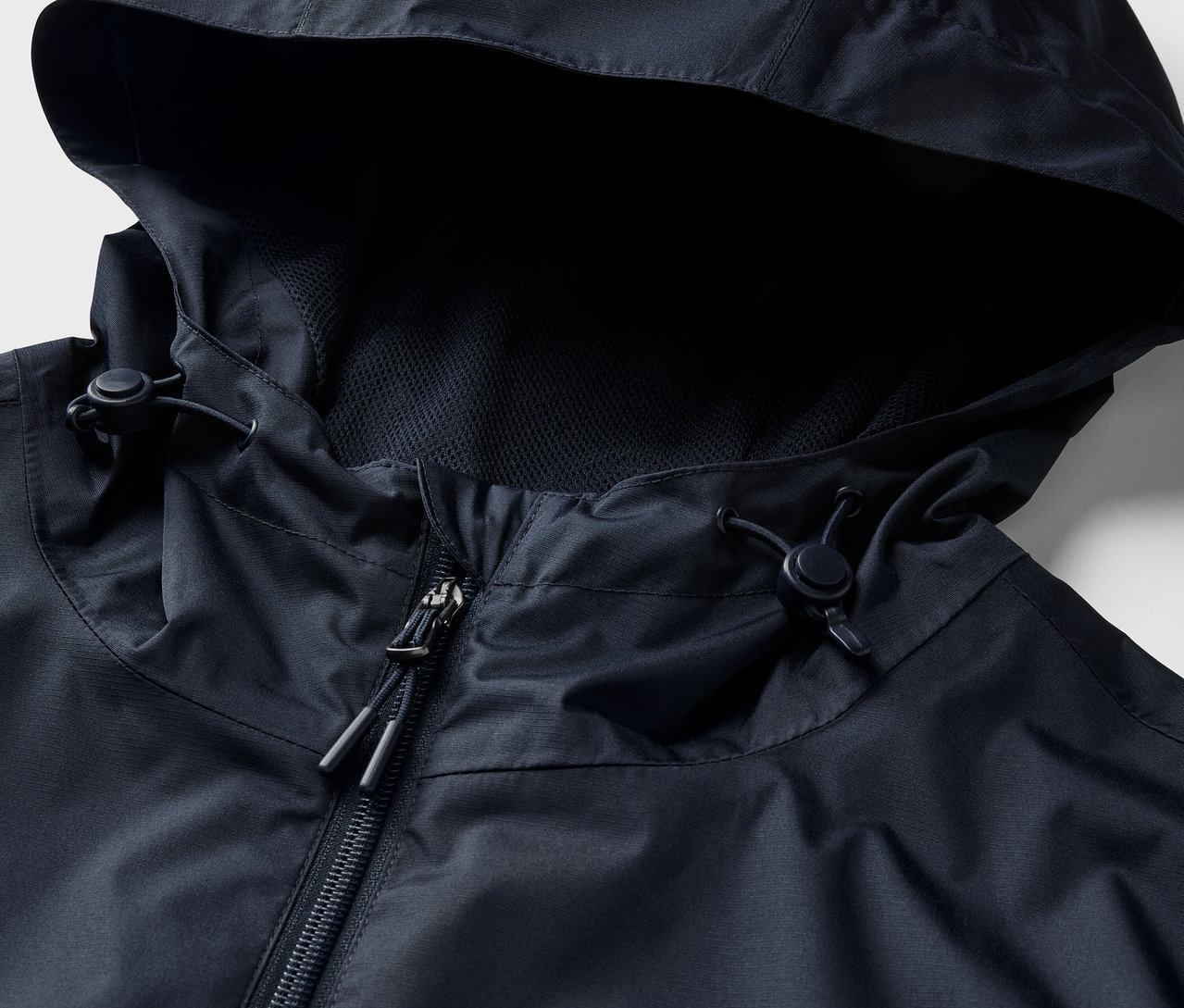 Detail bundy do deště, námořnická modrá, s kapucí a zipem.
