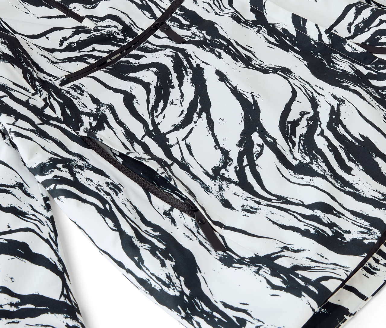 Detail bílého pyžama s černým abstraktním potiskem a lemováním.