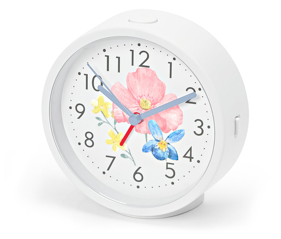 Budík s podsvícením, ciferník s květinovým vzorem.