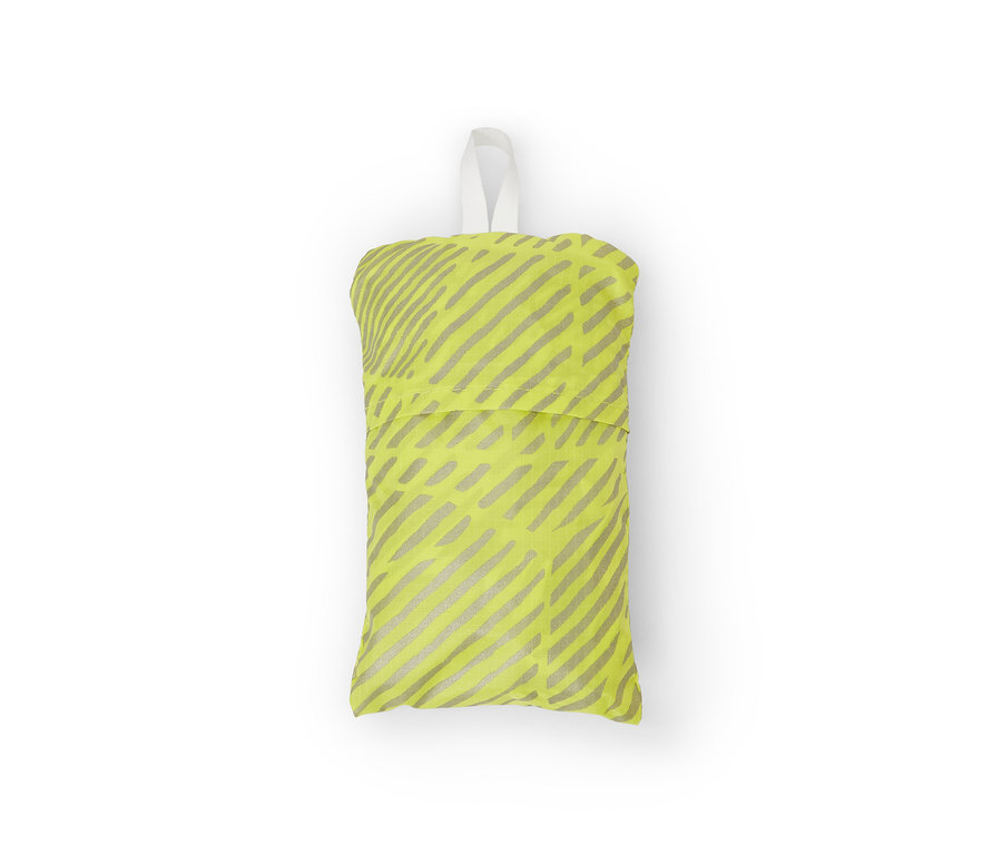 Složený nepromokavý ochranný návlek na batoh žluté barvy se stříbrnými pruhy a bílým poutkem.