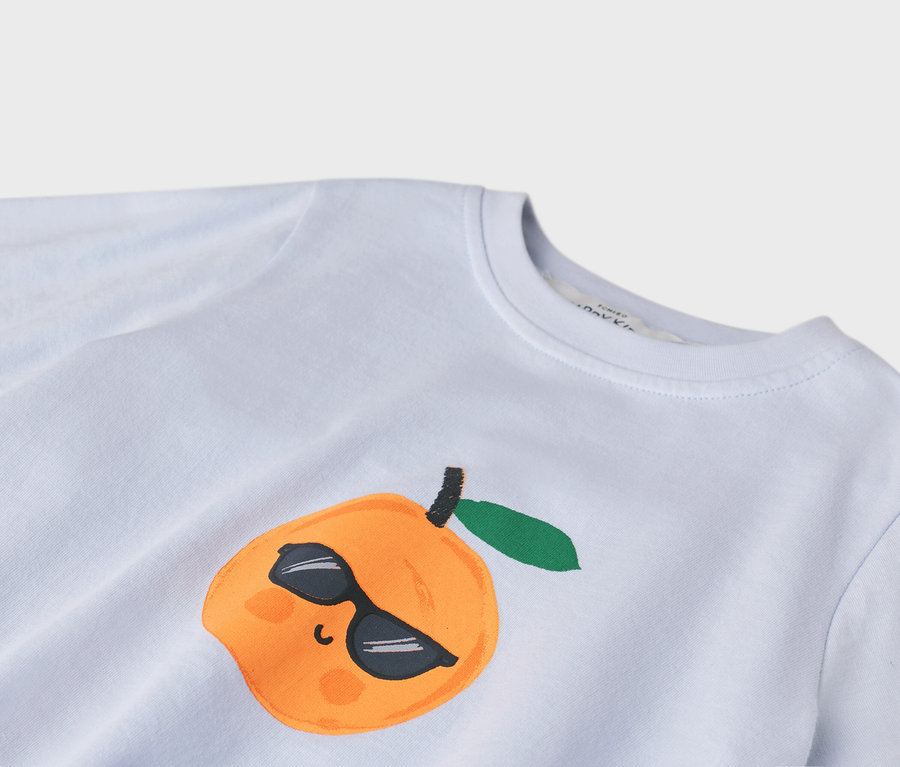 Detailní záběr světle modrého trička s oranžovou ilustrací broskve v slunečních brýlích.