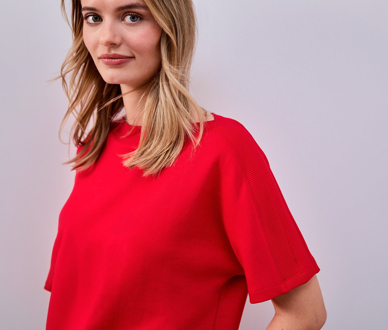 Žena má na sobě červené tričko s krátkým rukávem Street One.