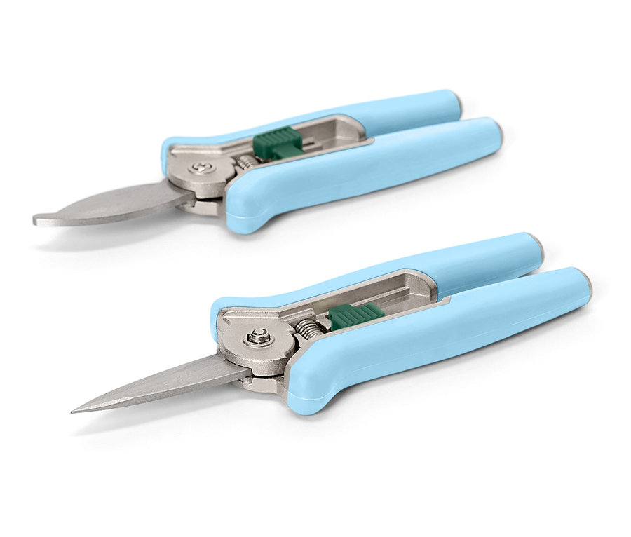 Dvoje světlé, modrozelené zahradní nůžky leží diagonálně na bílém pozadí.