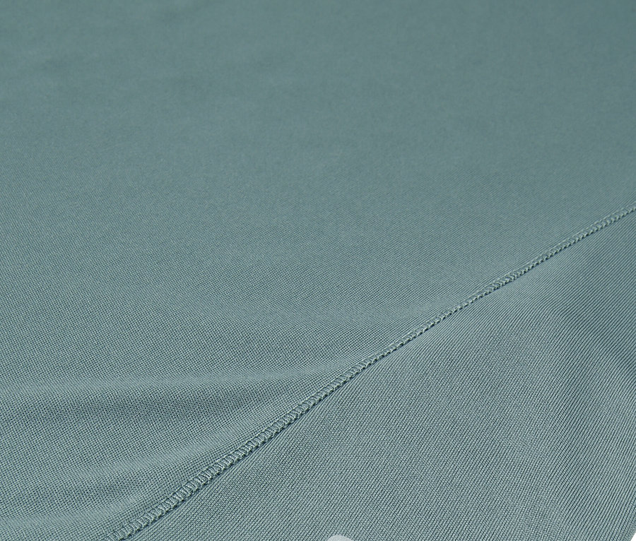 Detailní záběr tyrkysových šortek Fila se stříbrným logem.