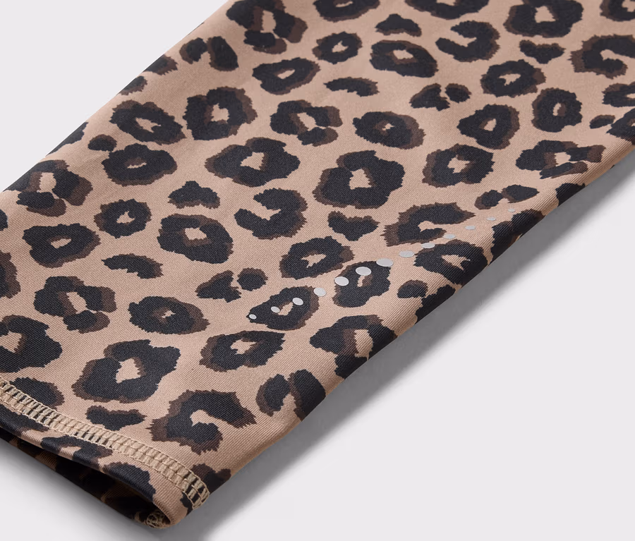 Detailní záběr rukávu s leopardím vzorem v odstínech hnědé a černé.