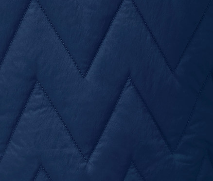 Detail modré běžecké termobundy s prošíváním do cik-cak vzoru.