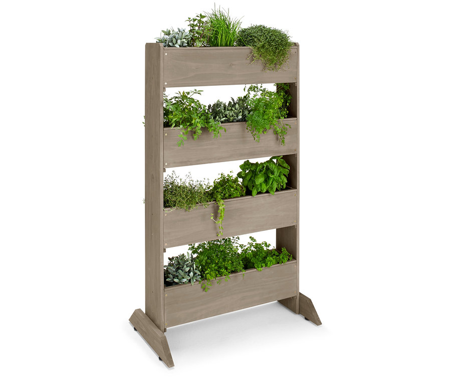 Dřevěný vertikální záhon s pěti patry osázenými různými bylinkami.