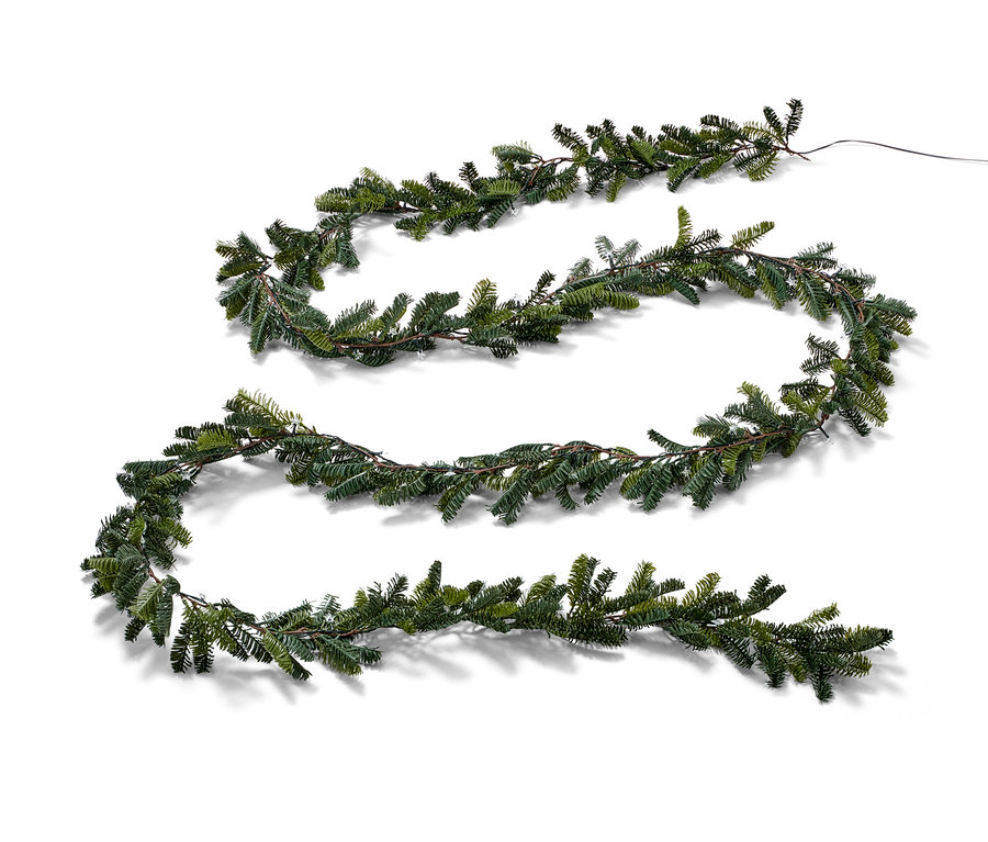 Dlouhá jedlová girlanda s LED světly leží na bílém pozadí.