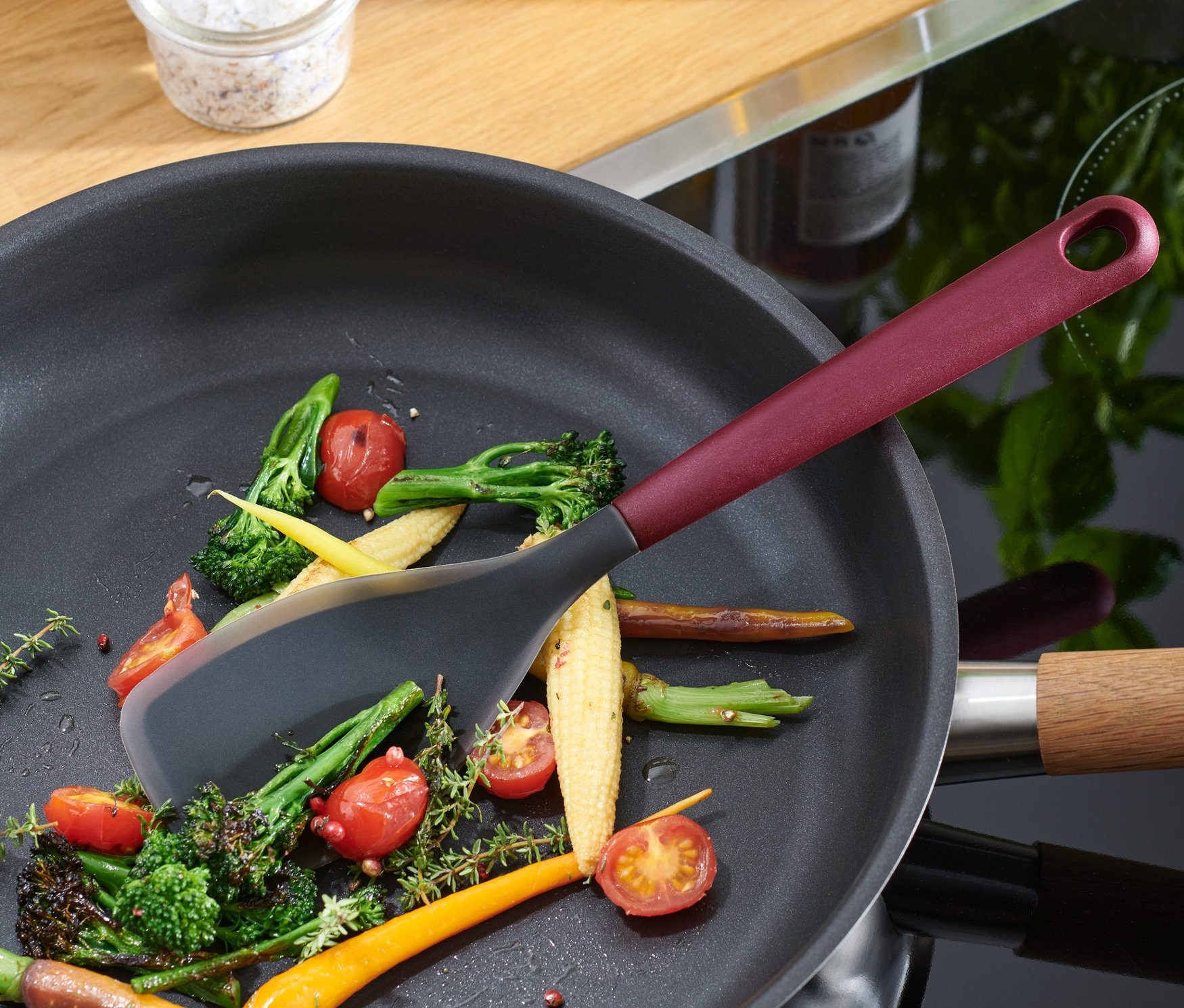 Multifunkční vařečka leží na pánvi se zeleninou.