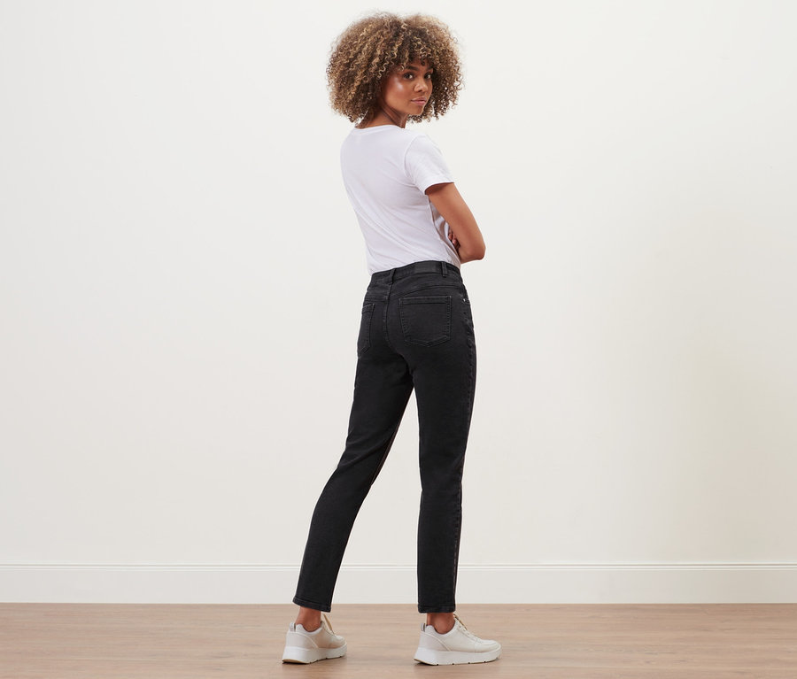 Žena pózuje v černých rovných džínách »Fit Juna« a bílém tričku.