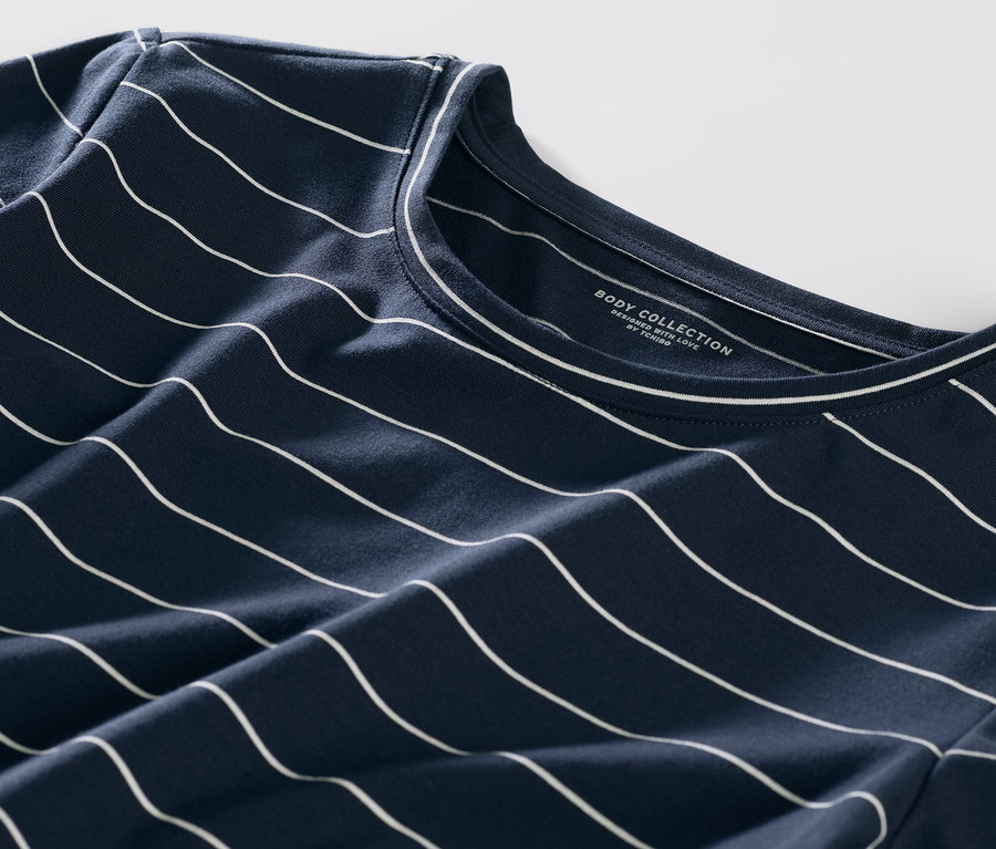 Detail modrého pyžama s bílými proužky.