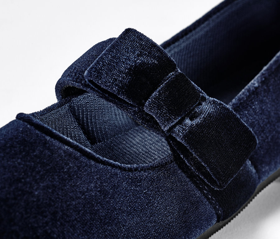 Detail dívčích sametových balerínek s mašlí.