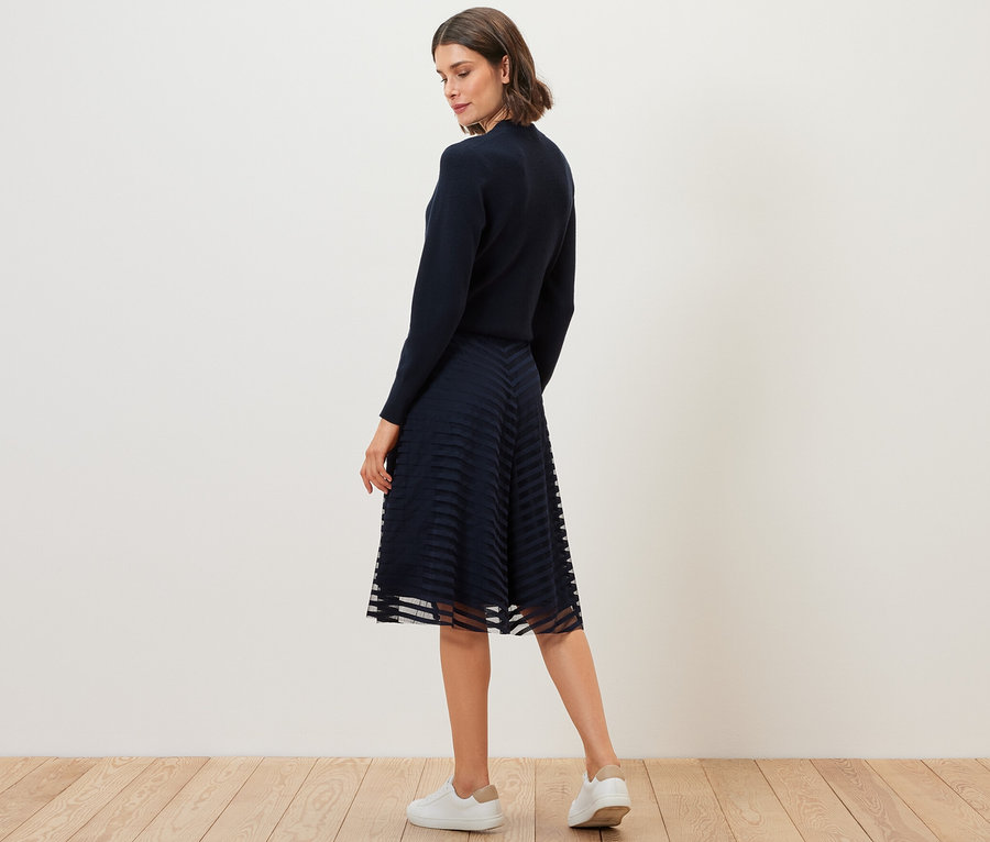 Žena pózuje v síťované sukni.