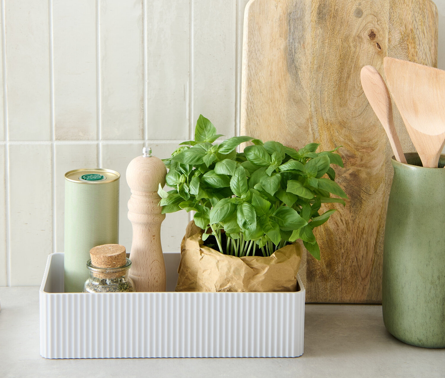 Bylinky, mlýnek a plechovka v bílém úložném boxu.