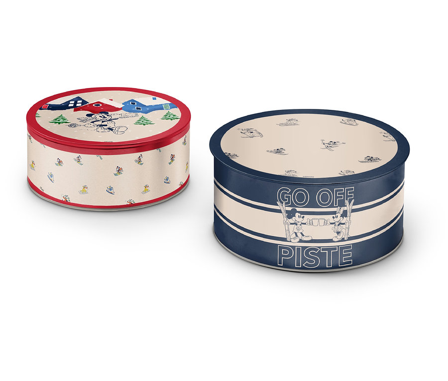 Dvě kulaté plechové dózy s různými vzory a barvami.