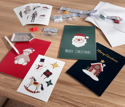 Rozložené vánoční přání s motivy medvídka, Santa Clause, sněhuláka a domu.