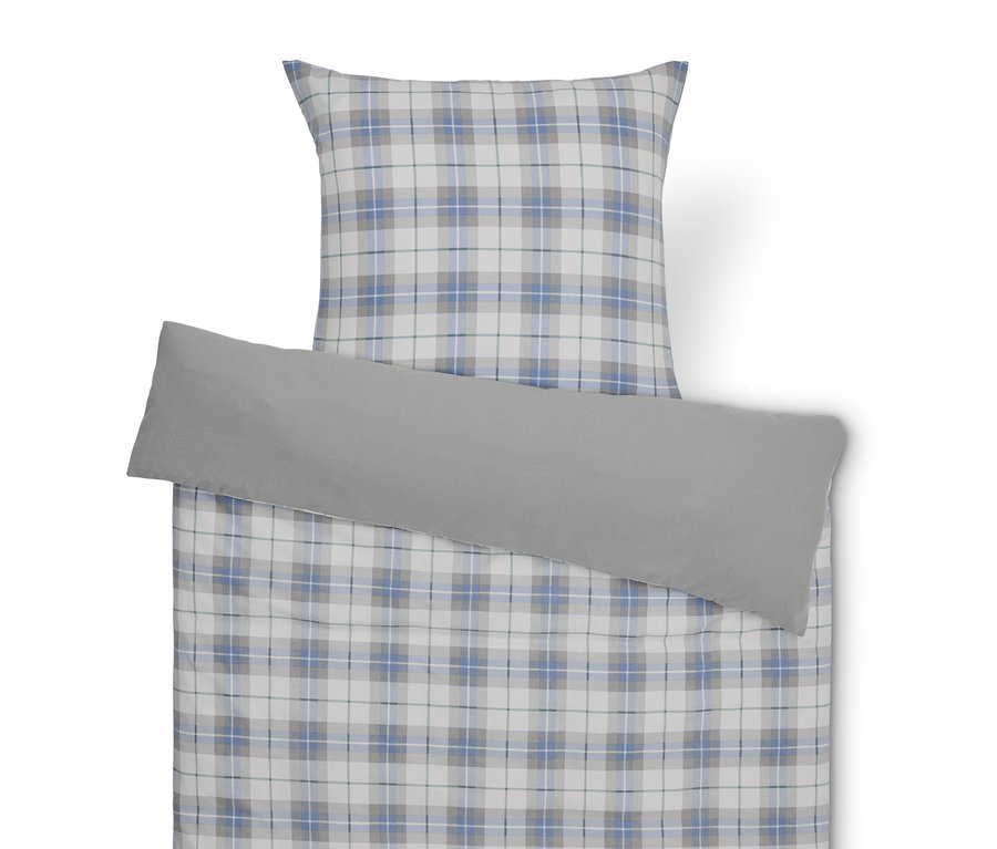 Ložní souprava s kostkovaným vzorem a šedým povlakem na polštář.