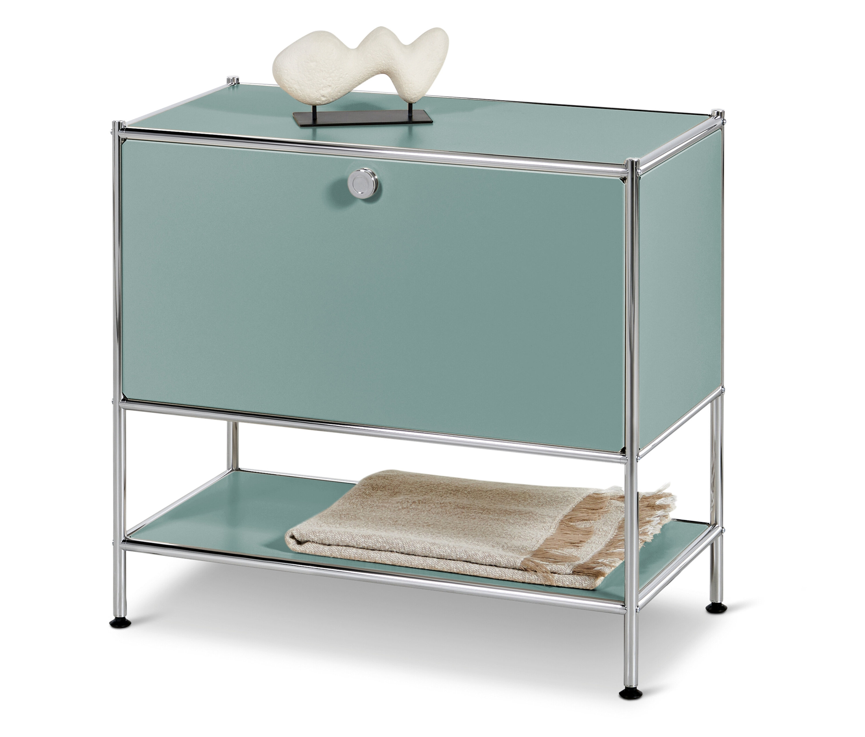 Tyrkysová skříňka s chromovaným rámem a bílou dekorací nahoře, deka dole.