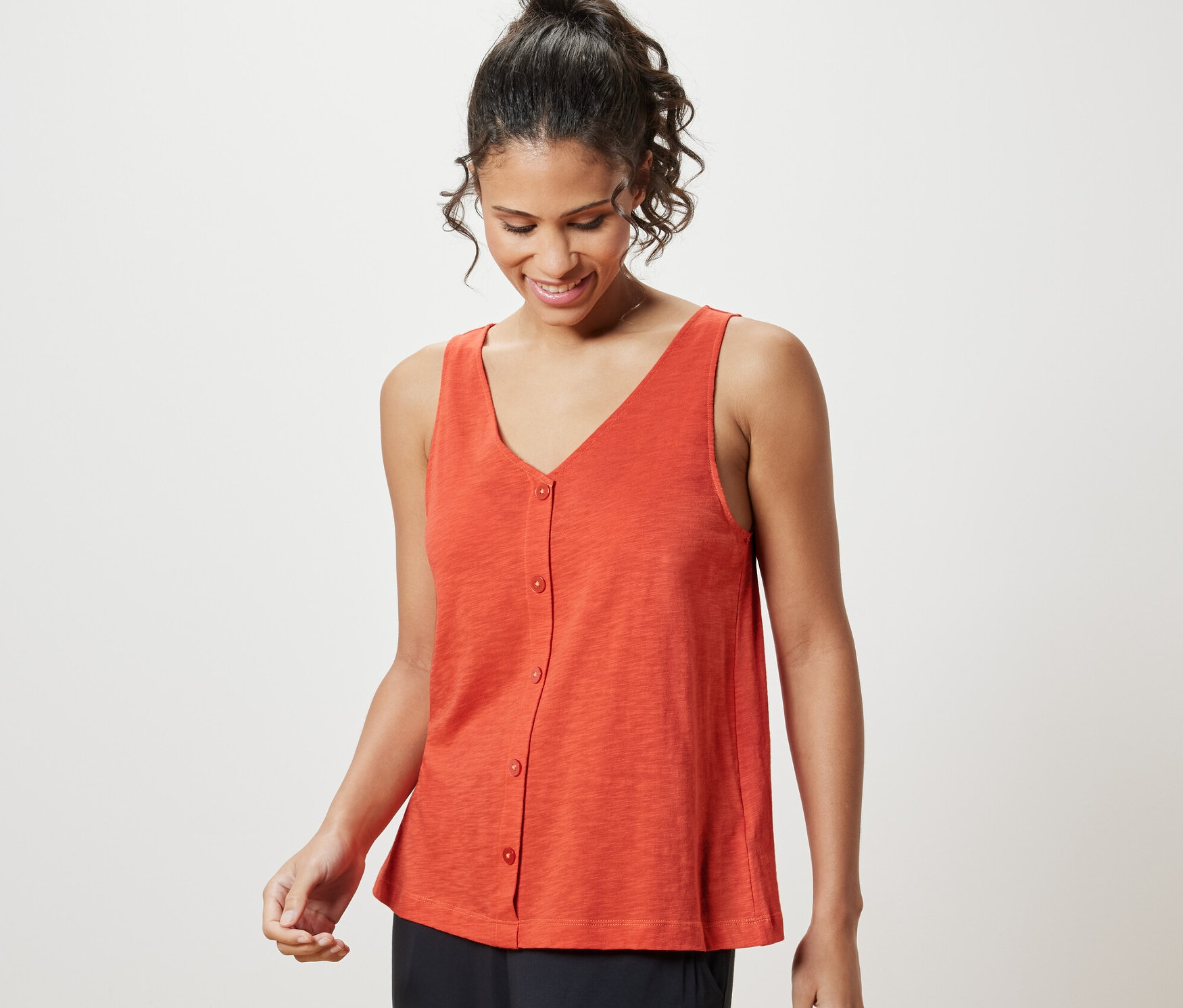 Žena má na sobě oranžový top z modalové směsi.