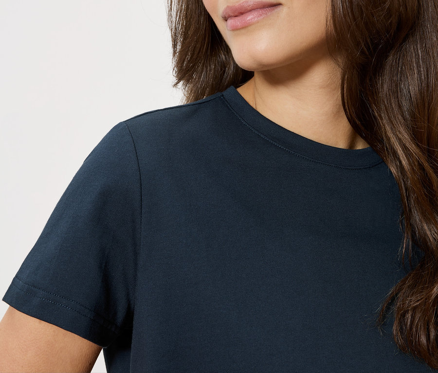 Detailní záběr ženy v tmavě modrém tričku.