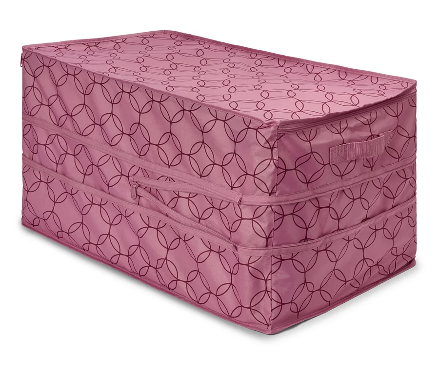 Obdélníkový růžový úložný box se zipy a vzorem protínajících se kruhů leží na podlaze.