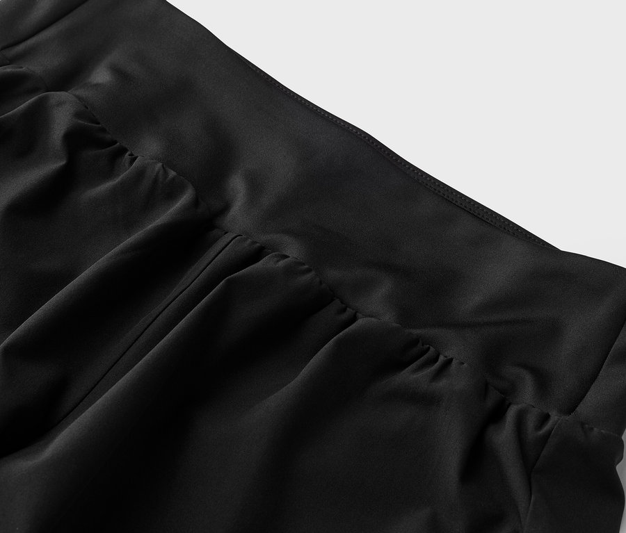 Detailní záběr na černou látku s detaily nařasení v pase.