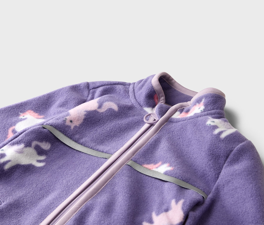 Detail fialové fleecové bundy se vzorem jednorožce na zip.