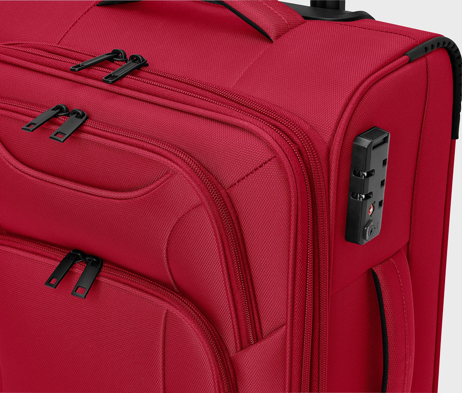 Detailní pohled na červený látkový kufr s černými zipy a číselným zámkem.
