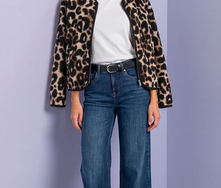 Žena v bundě Street One s leopardím vzorem, bílém tričku, modrých džínách a černém pásku.