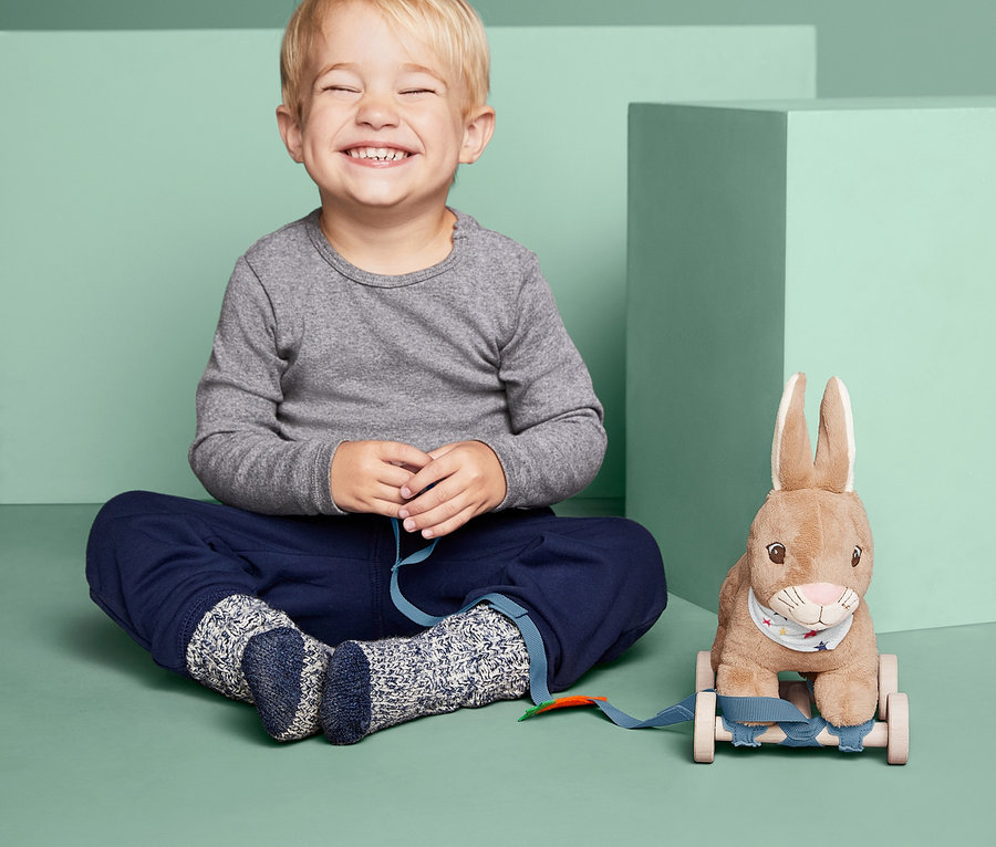 Chlapeček sedí se zavřenýma očima vedle tahacího zajíčka.