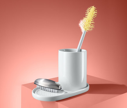 Bílý keramický organizér na potřeby na umývání nádobí se žlutým kartáčem.