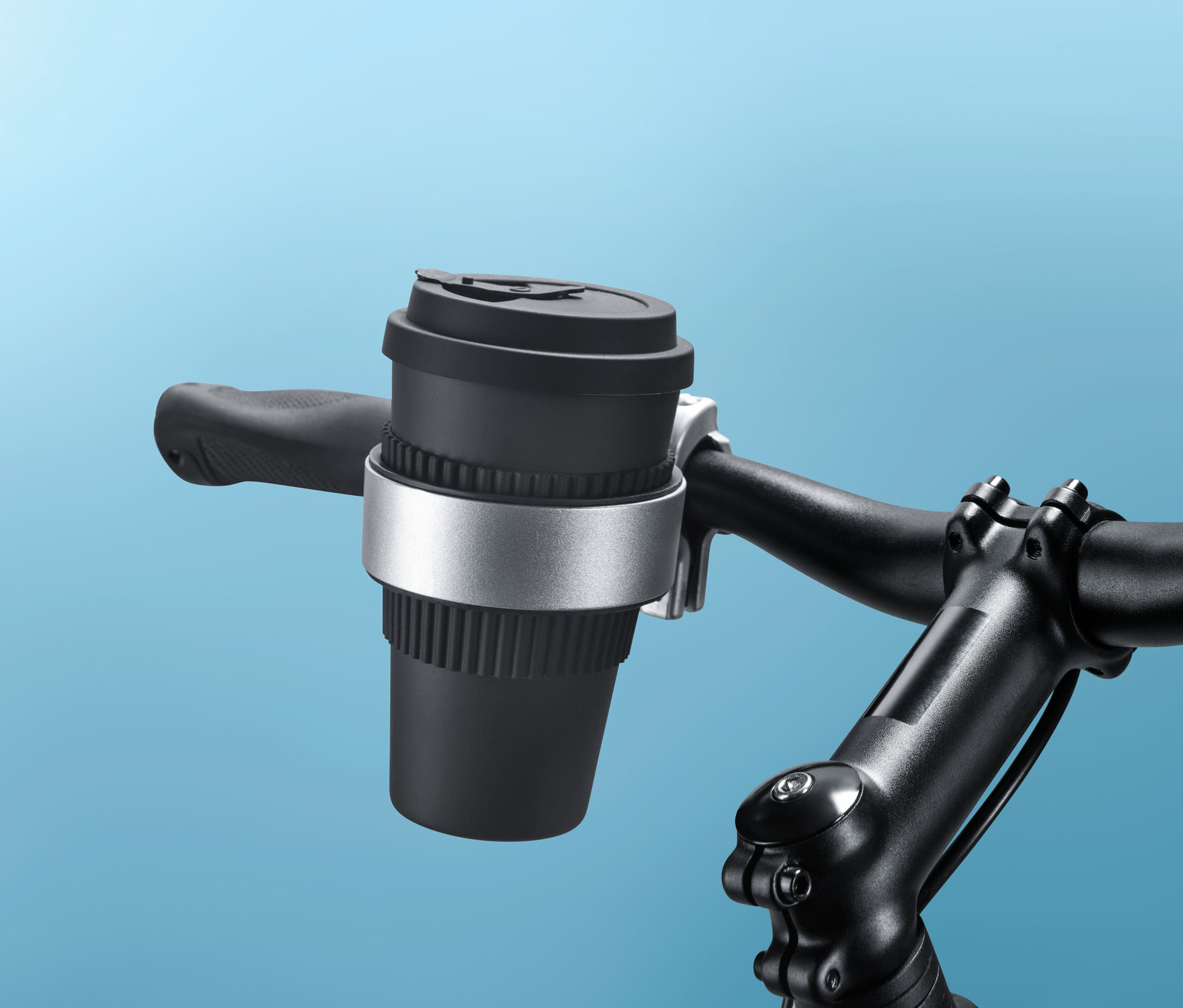 Černý držák na nápoje na jízdní kolo připevněný na řídítkách kola.