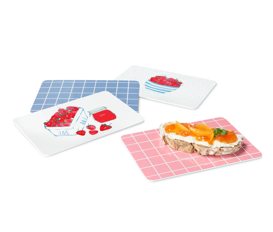 Čtyři krájecí prkénka s různými vzory a jídlem.