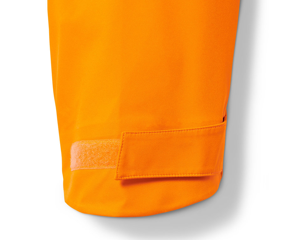 Detail oranžové hardshellové lyžařské bundy se suchým zipem.