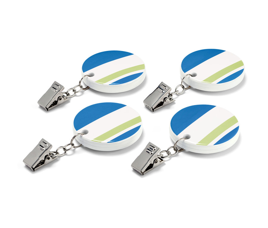 Čtyři závaží na ubrus s modrými a zelenými pruhy.