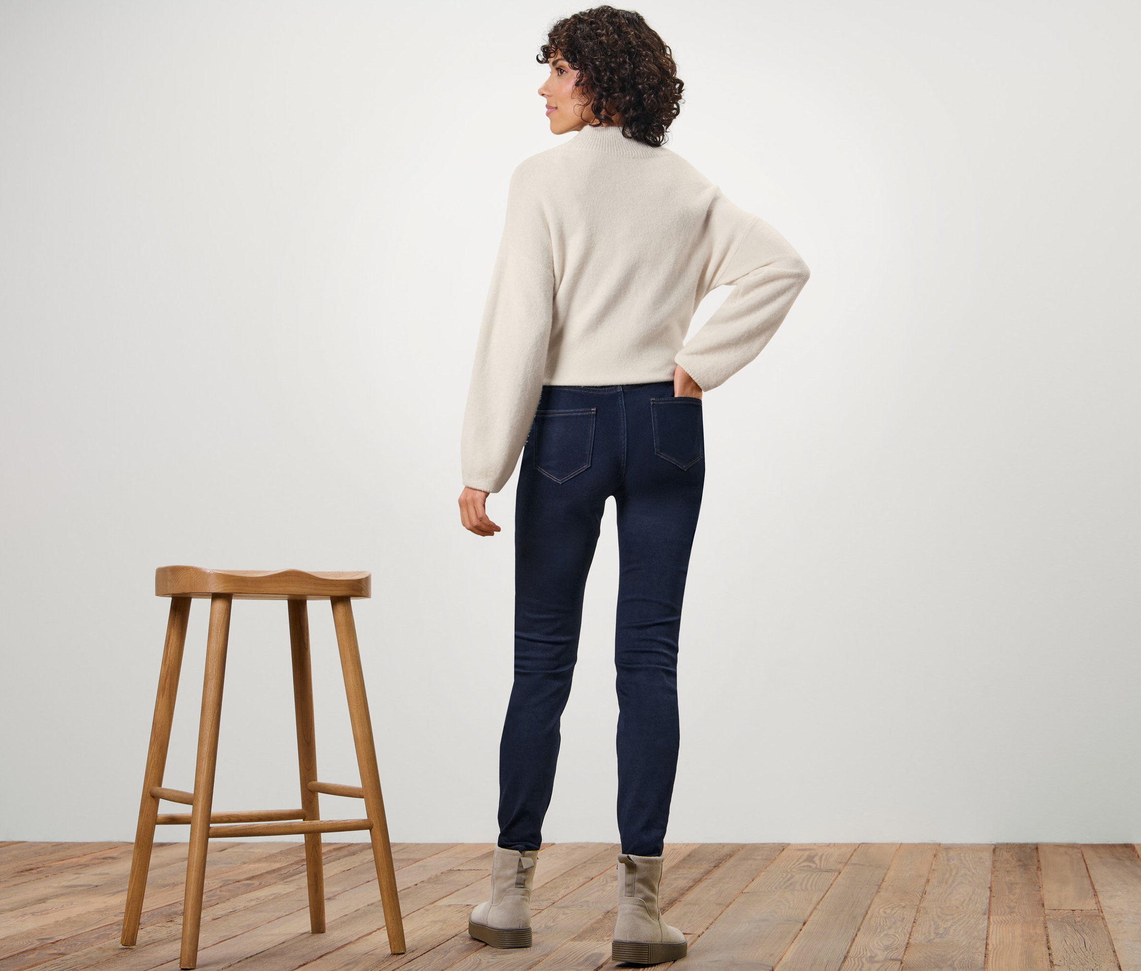 Žena stojí zády k fotoaparátu a má na sobě termo legíny.