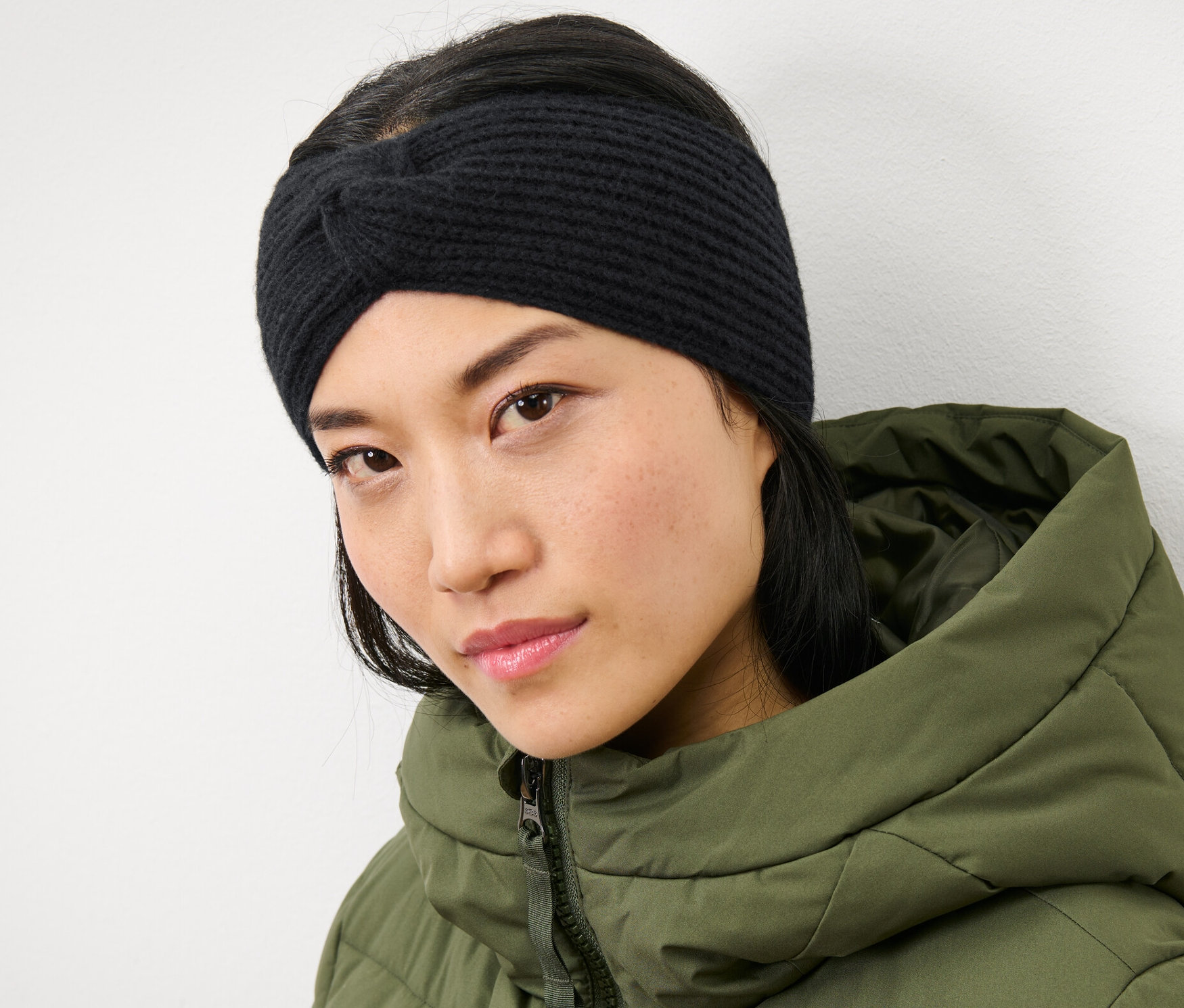 Žena má na sobě černou pletenou čelenku.