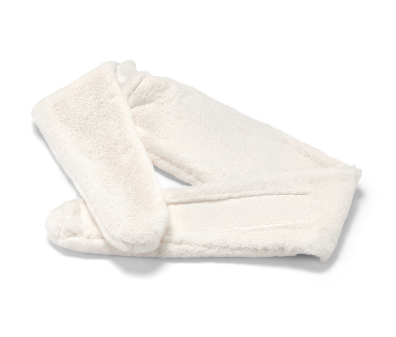 Bílý plyšový termofor s popruhem leží na bílém pozadí.