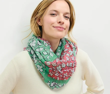 Žena má na sobě kruhovou šálu s potiskem.