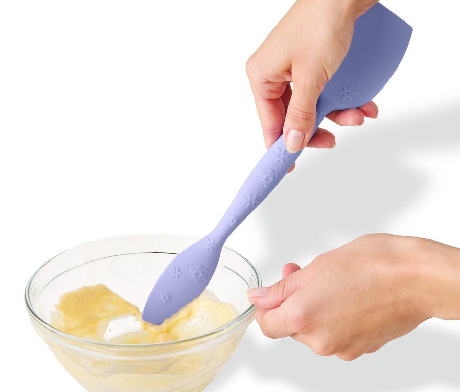 Osoba míchá těsto v míse multifunkční lžící na těsto.